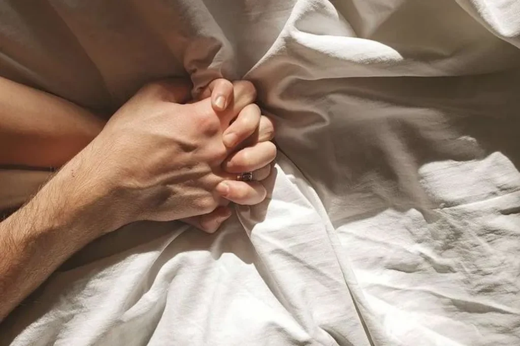 yatakta el ele tutuşan çift