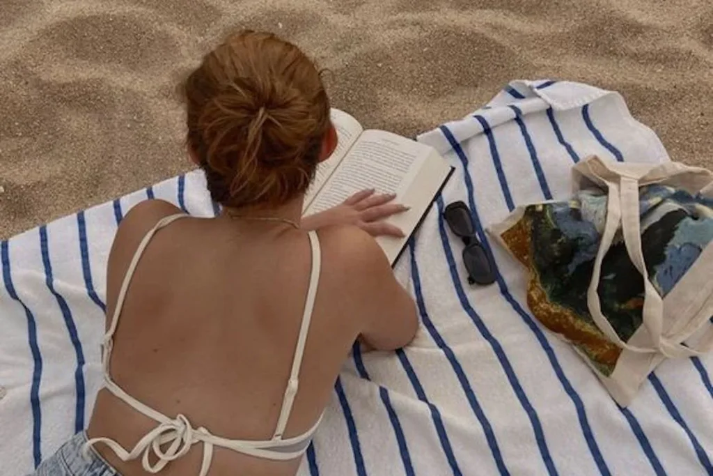 sahilde kitap okuyan kadın