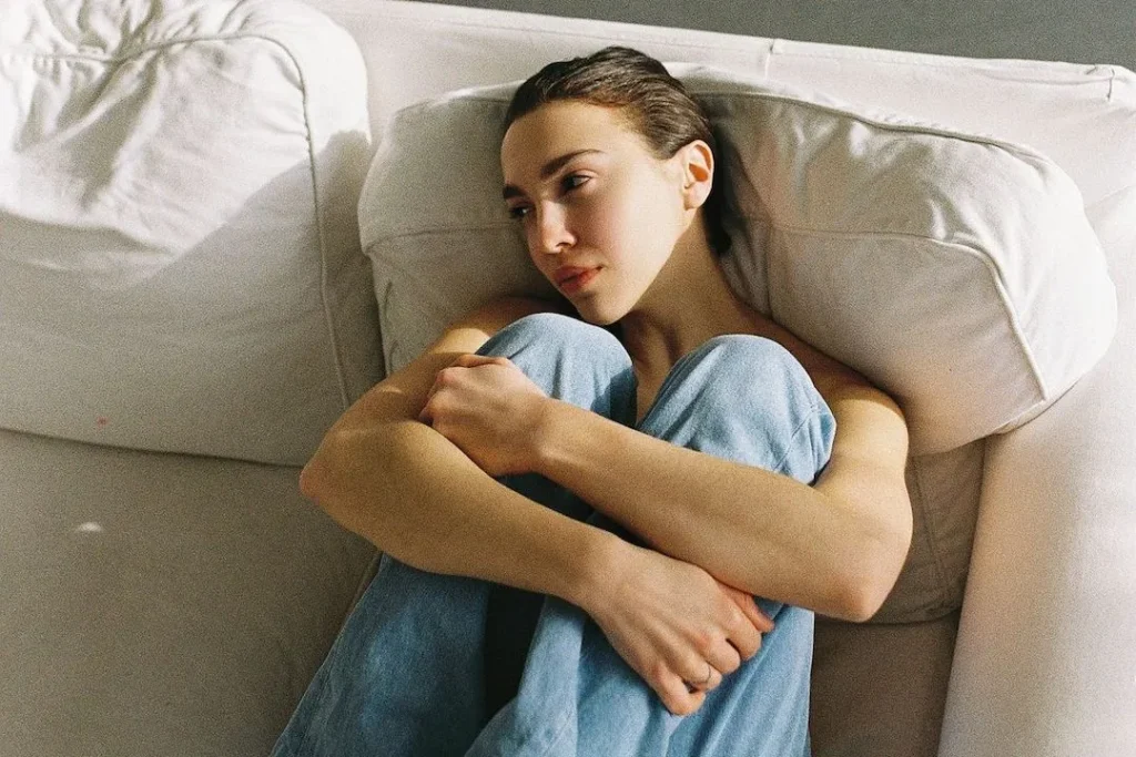 dizlerini karnına çekmiş kadın