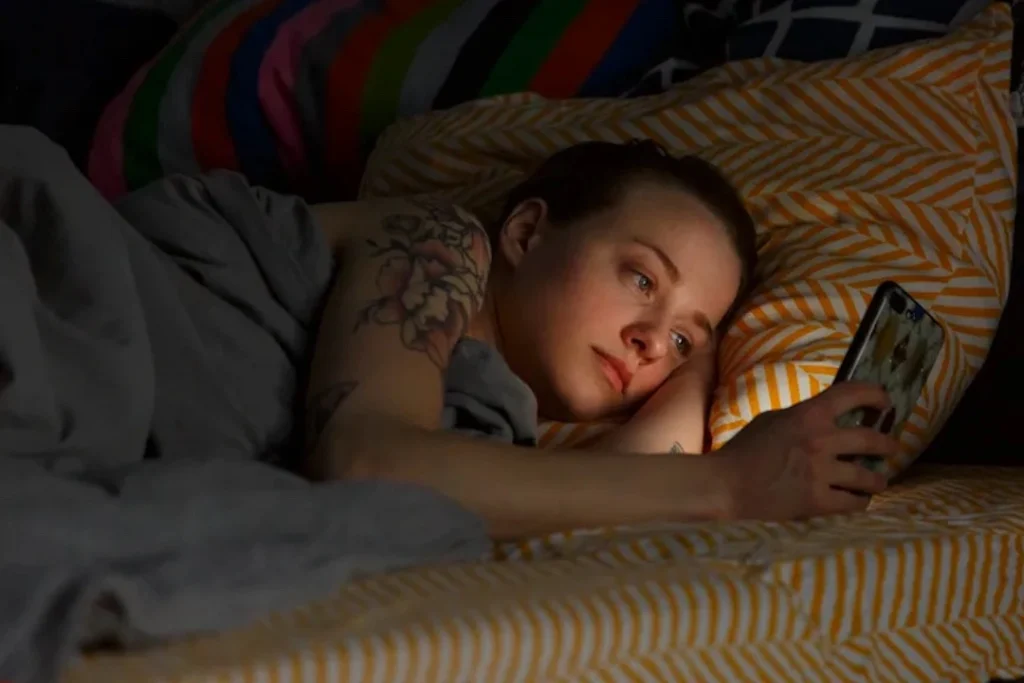 yatakta telefonuna bakan kadın